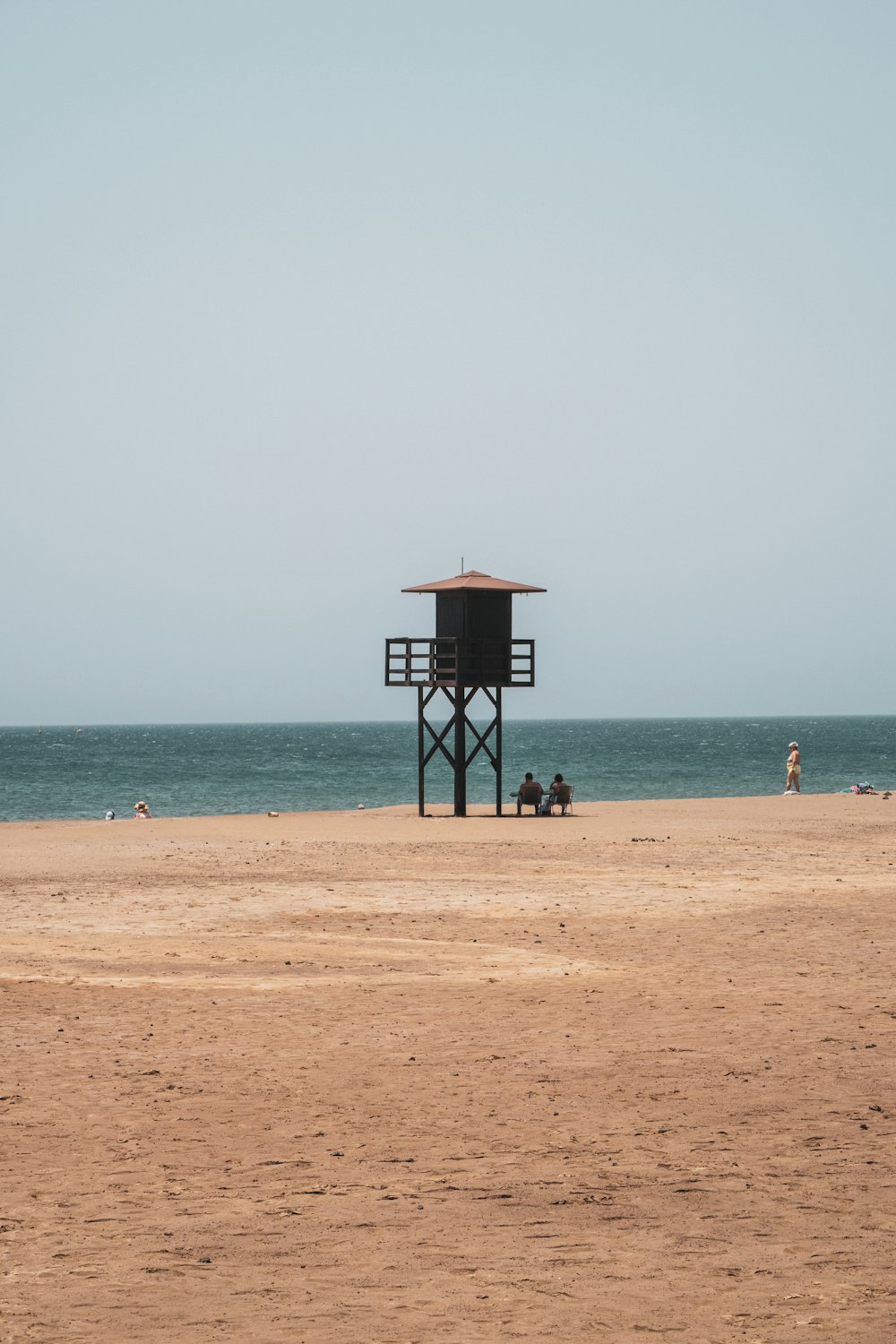 a lifeguard tower sitting on top of a sandy beach