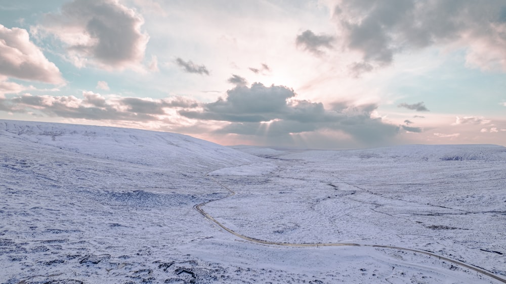 a snow covered hill with a road going through it