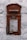 A vintage red postal box embedded in a white textured wall, featuring an emblem and the inscription 'G R' at the top. Below is a slot labeled 'Letters Only' and further down is a notice with collection times for mail from Monday to Saturday.