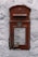 A vintage red postal box embedded in a white textured wall, featuring an emblem and the inscription 'G R' at the top. Below is a slot labeled 'Letters Only' and further down is a notice with collection times for mail from Monday to Saturday.
