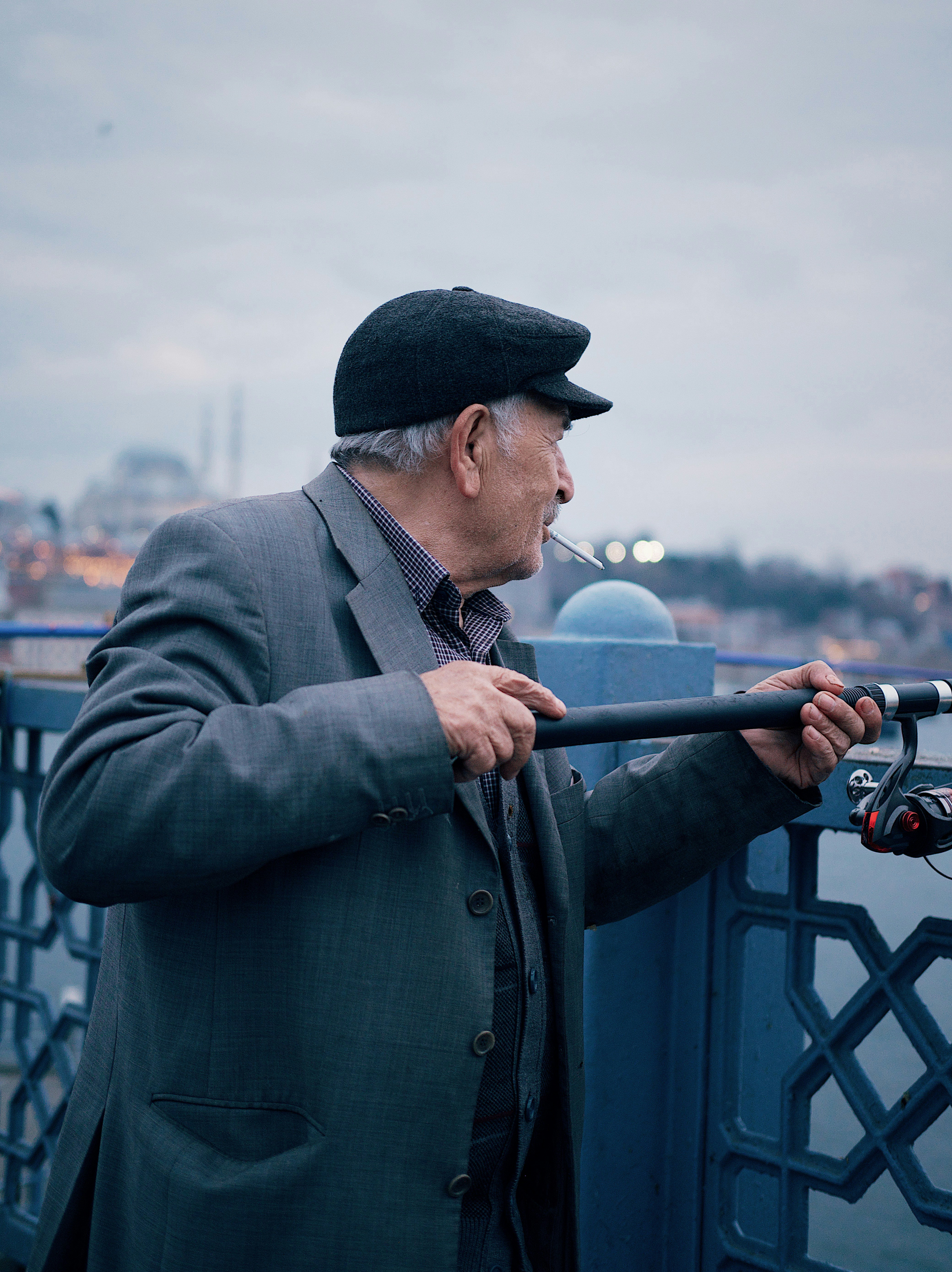 a man smoking a cigarette on a bridge