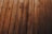 Wooden planks arranged in parallel, displaying a natural grain pattern with knots and varying shades of brown.