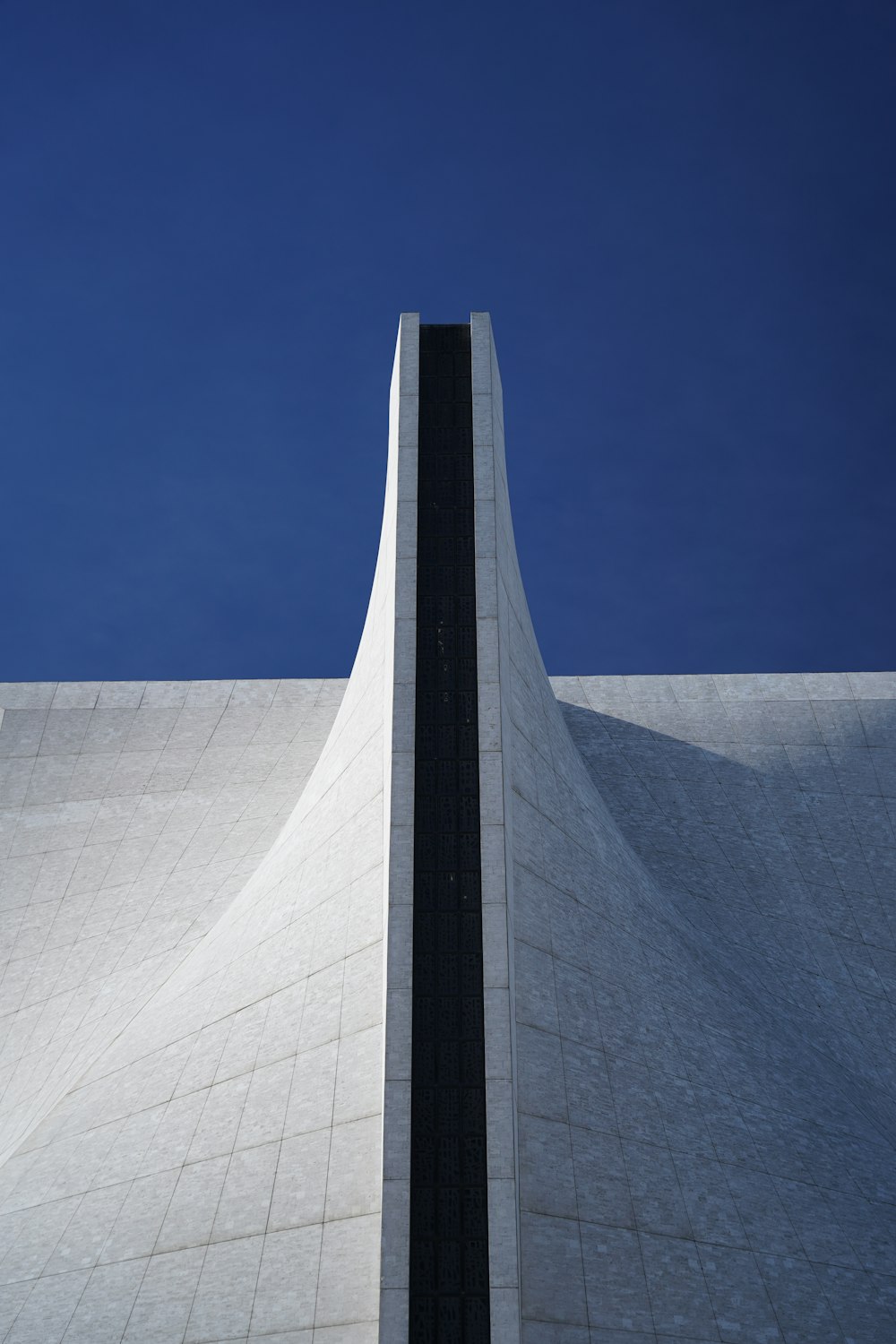 a tall white building with a black stripe on it's side