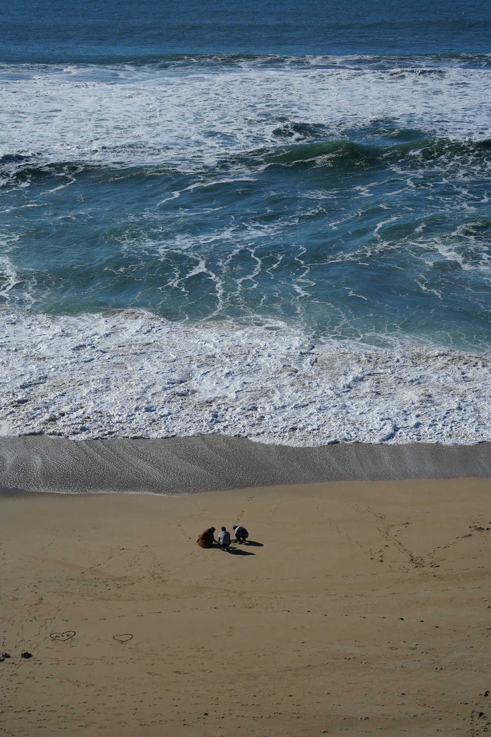 a couple of people laying on top of a sandy beach