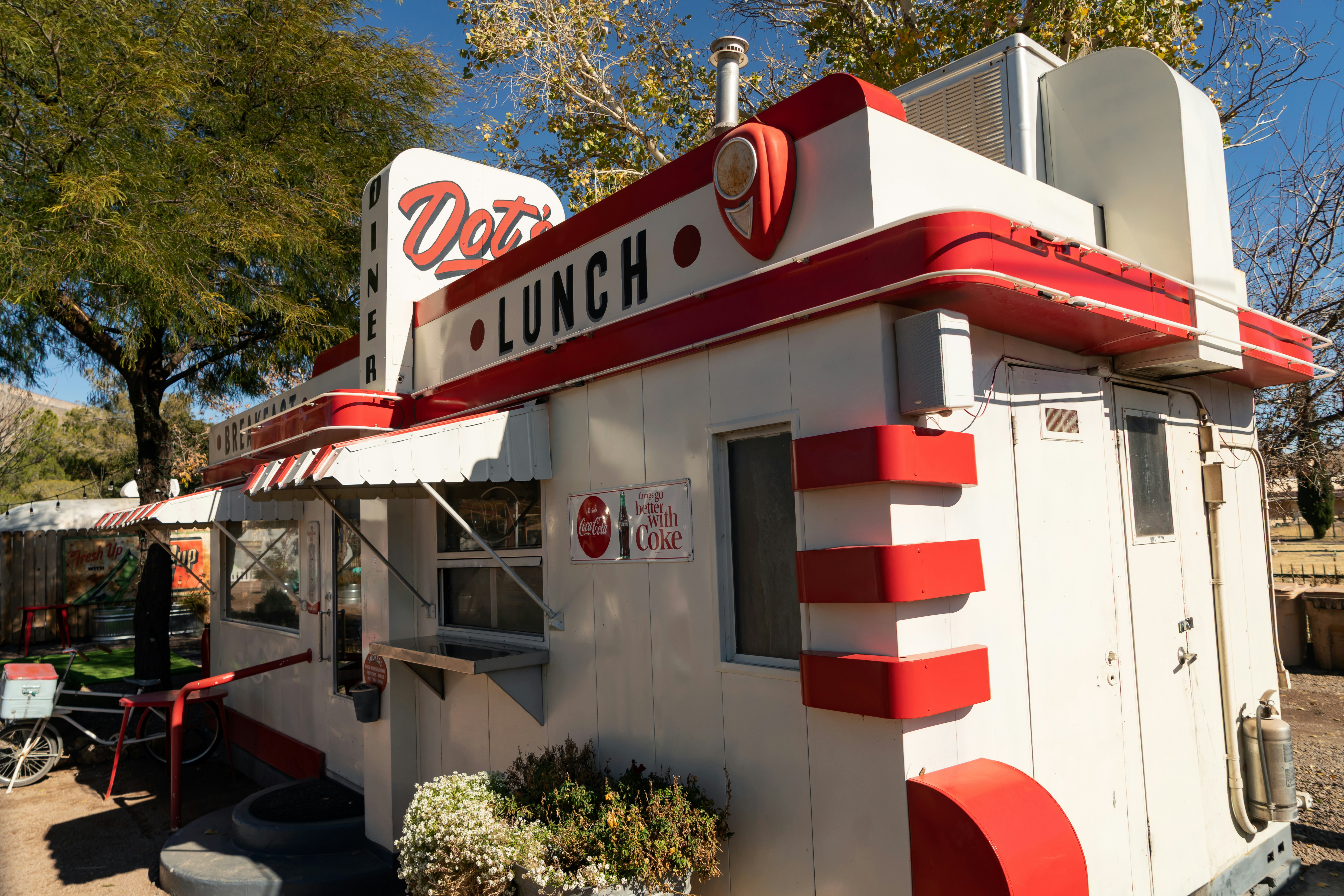 a red and white building with a sign that says lunch, In Bisbee, you can spend the night in an airplane, yacht, or old airstream trailer, and then wake up to a great breakfast at Dot