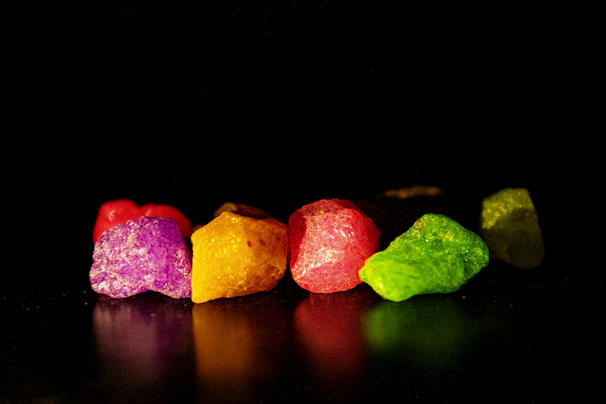 Purple lithium-rich rock formations captured with intricate detail and contrast on a black background.