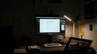 A clean desk setup showing a laptop with an open digital guide on maintenance KPIs against a dark navy background.