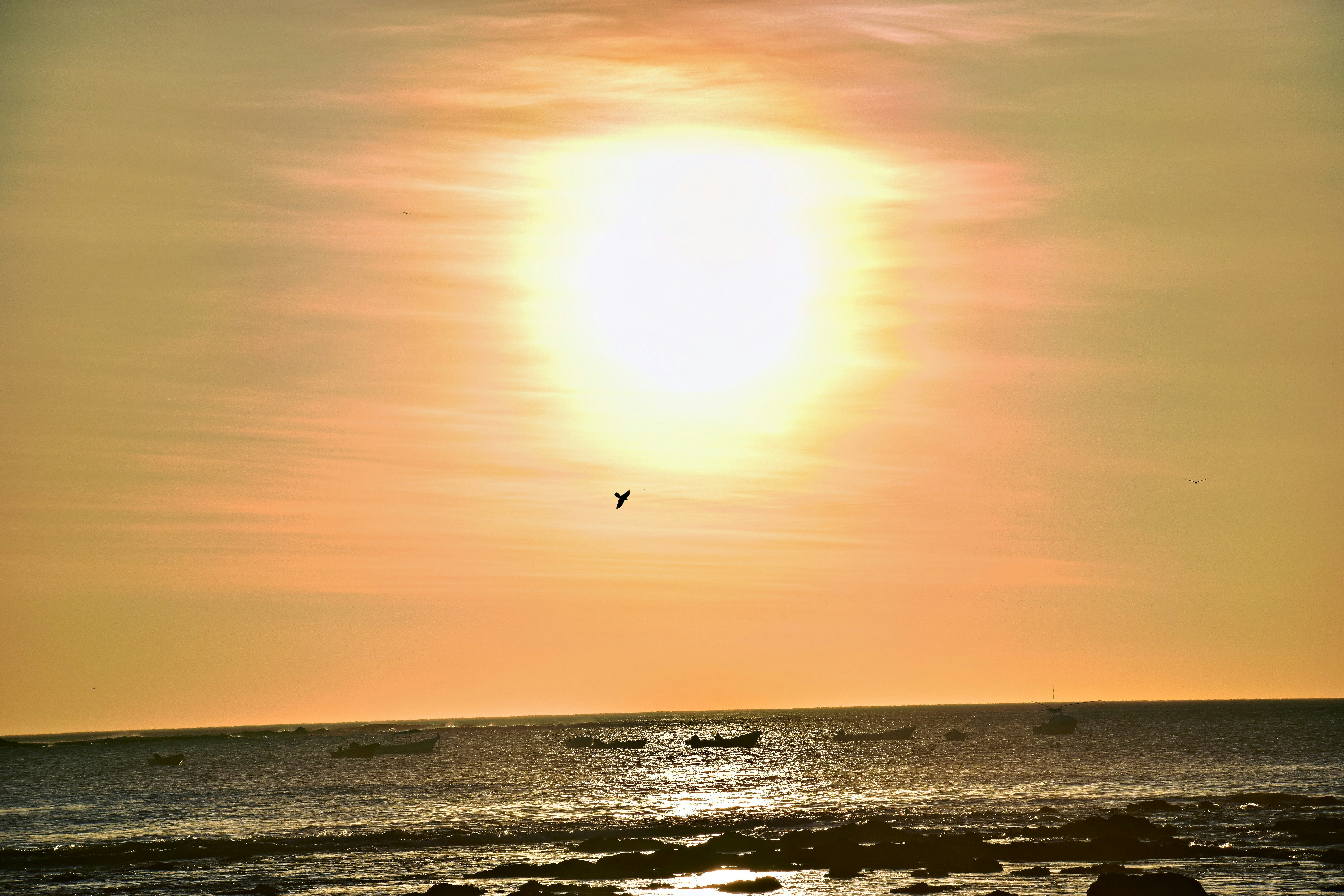 the sun is setting over the ocean with boats in the water, 