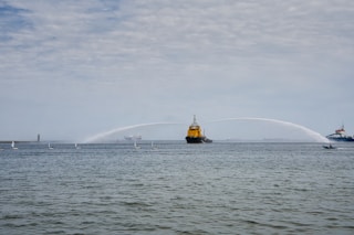 a large yellow boat spraying water on a large body of water
