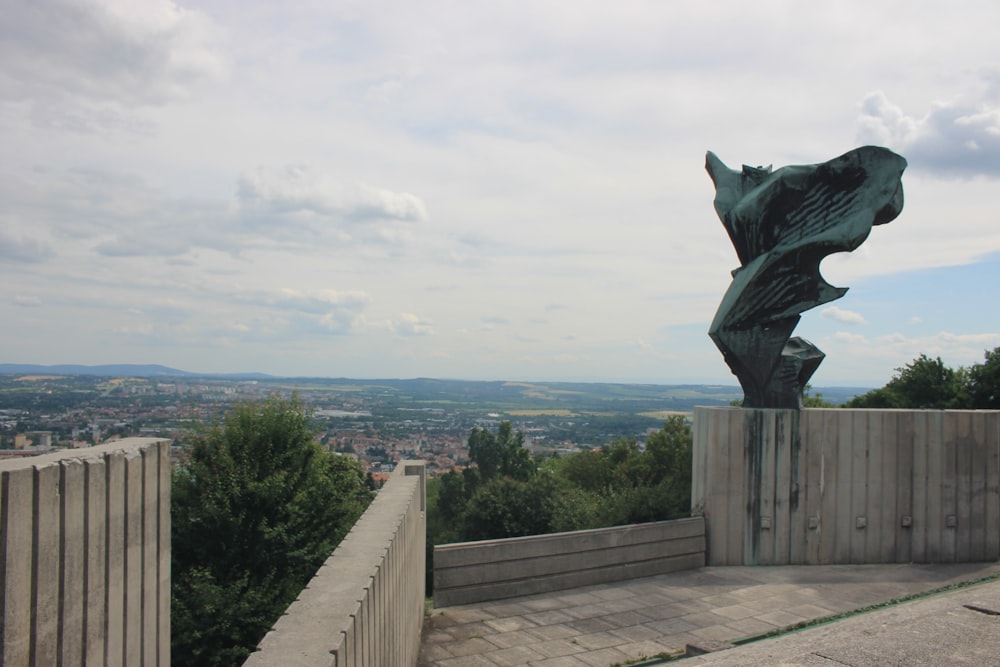 a statue of a fish on top of a wooden fence