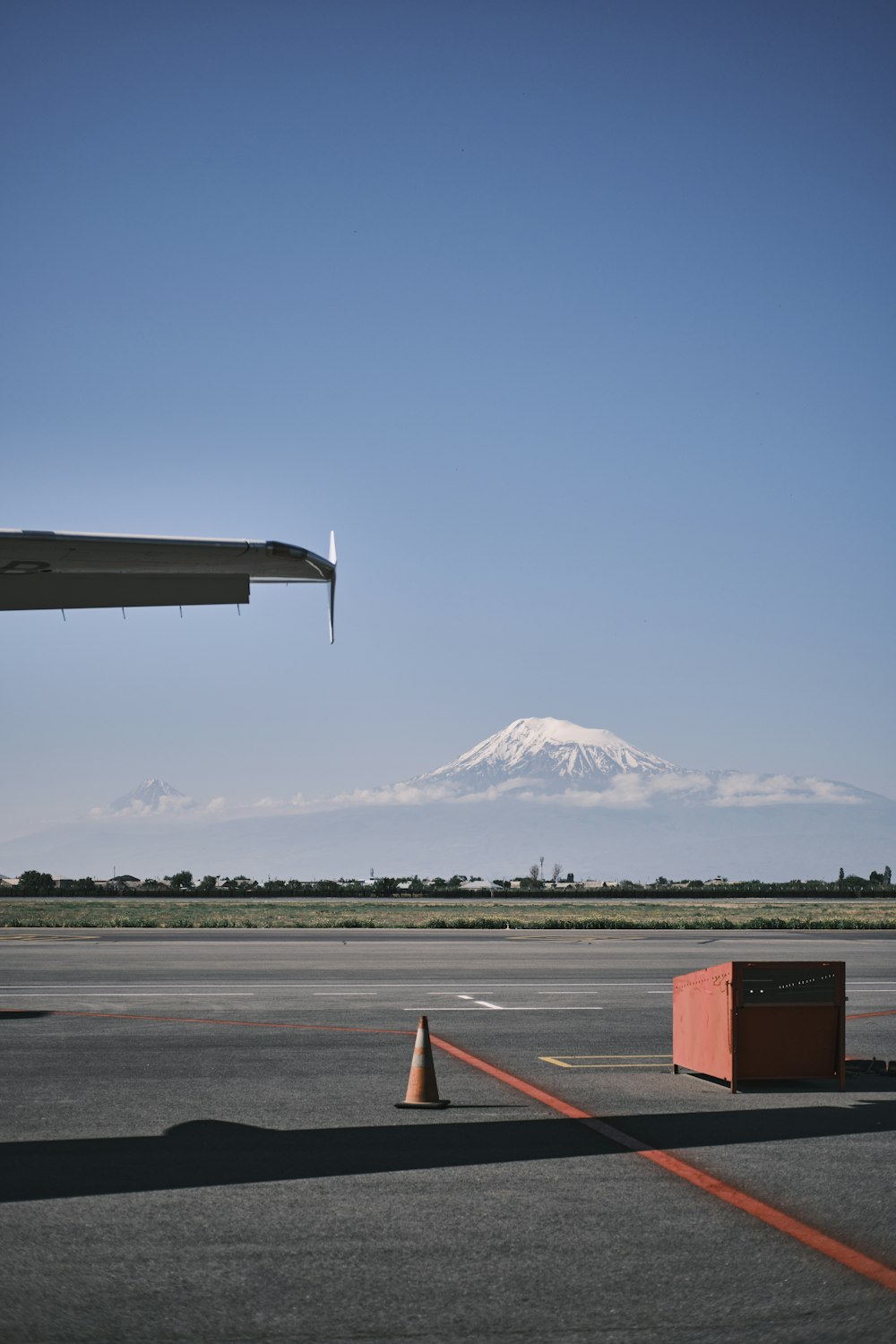 an airplane is flying over an airport with a mountain in the background