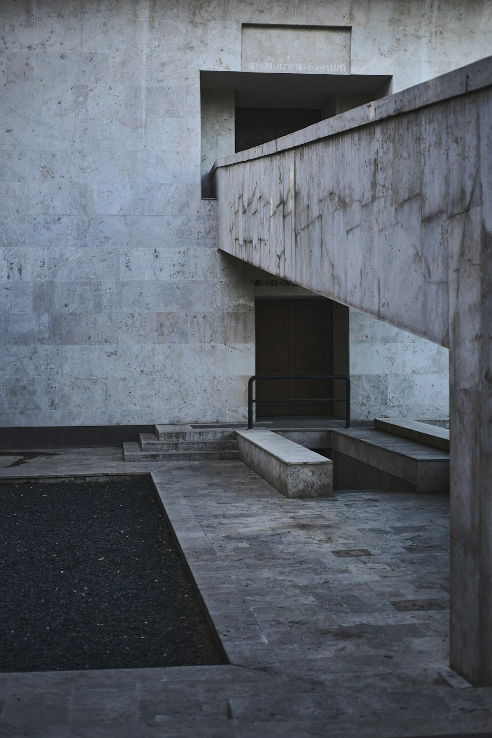 a concrete building with stairs and a bench