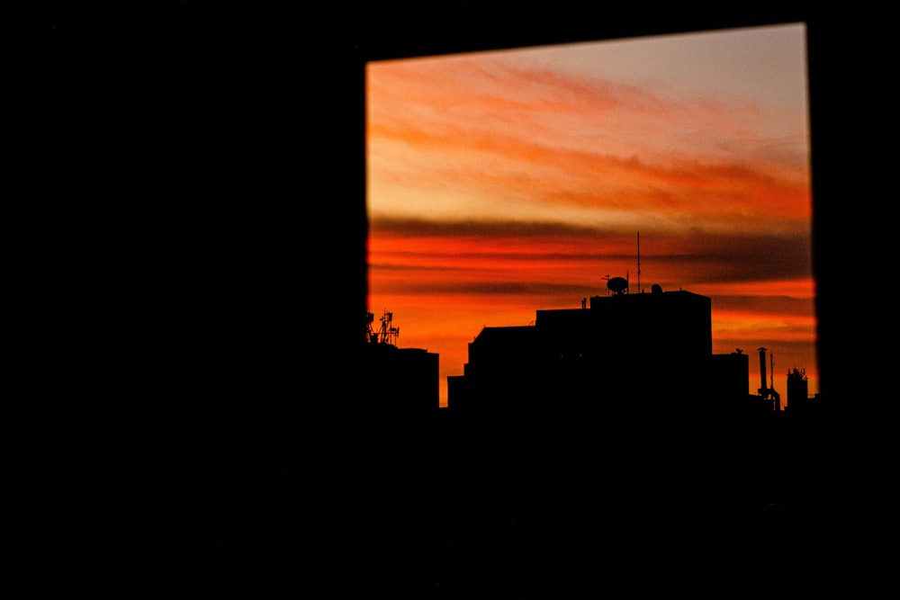 a view of a city from a window at sunset