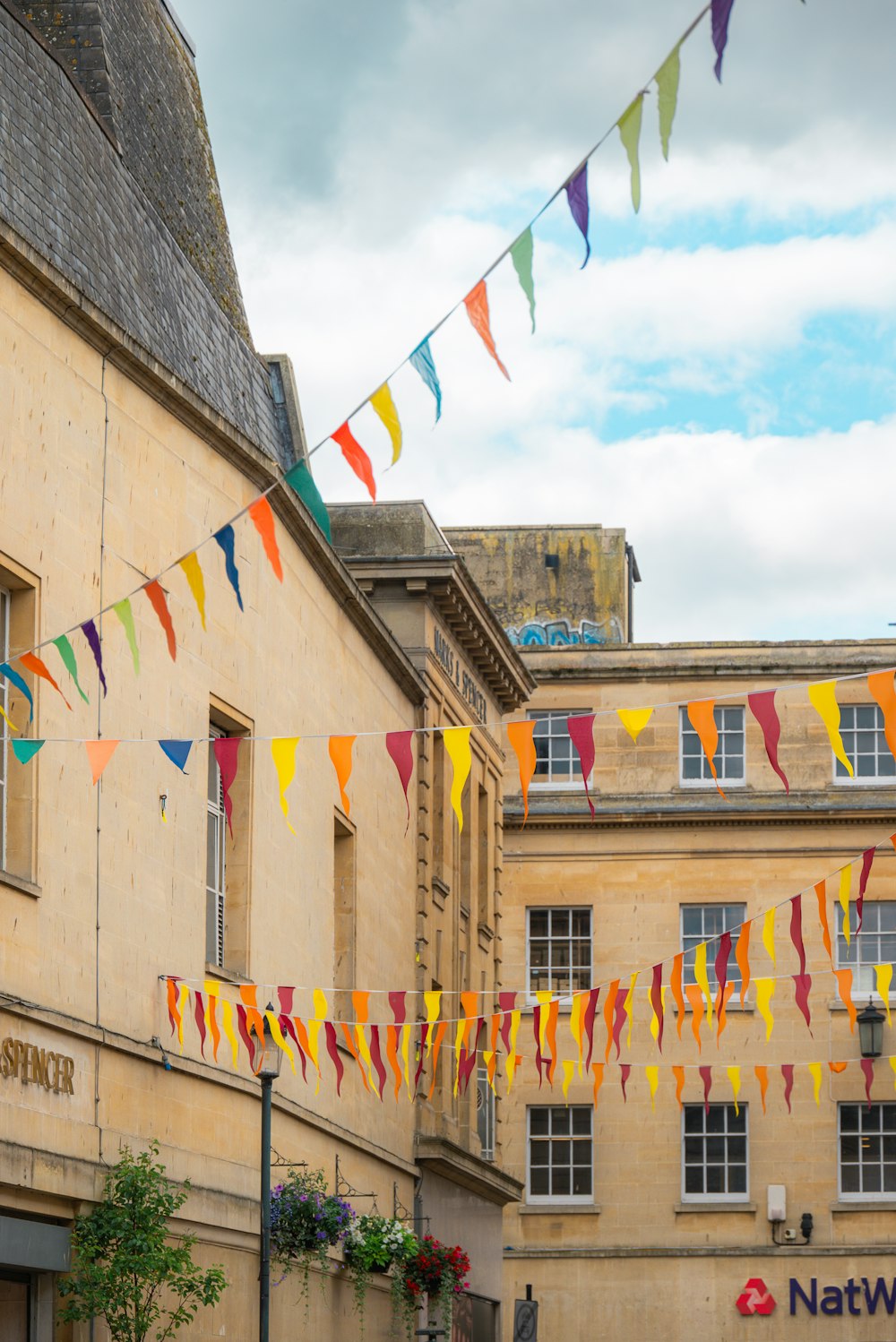 a group of flags hanging from the side of a building