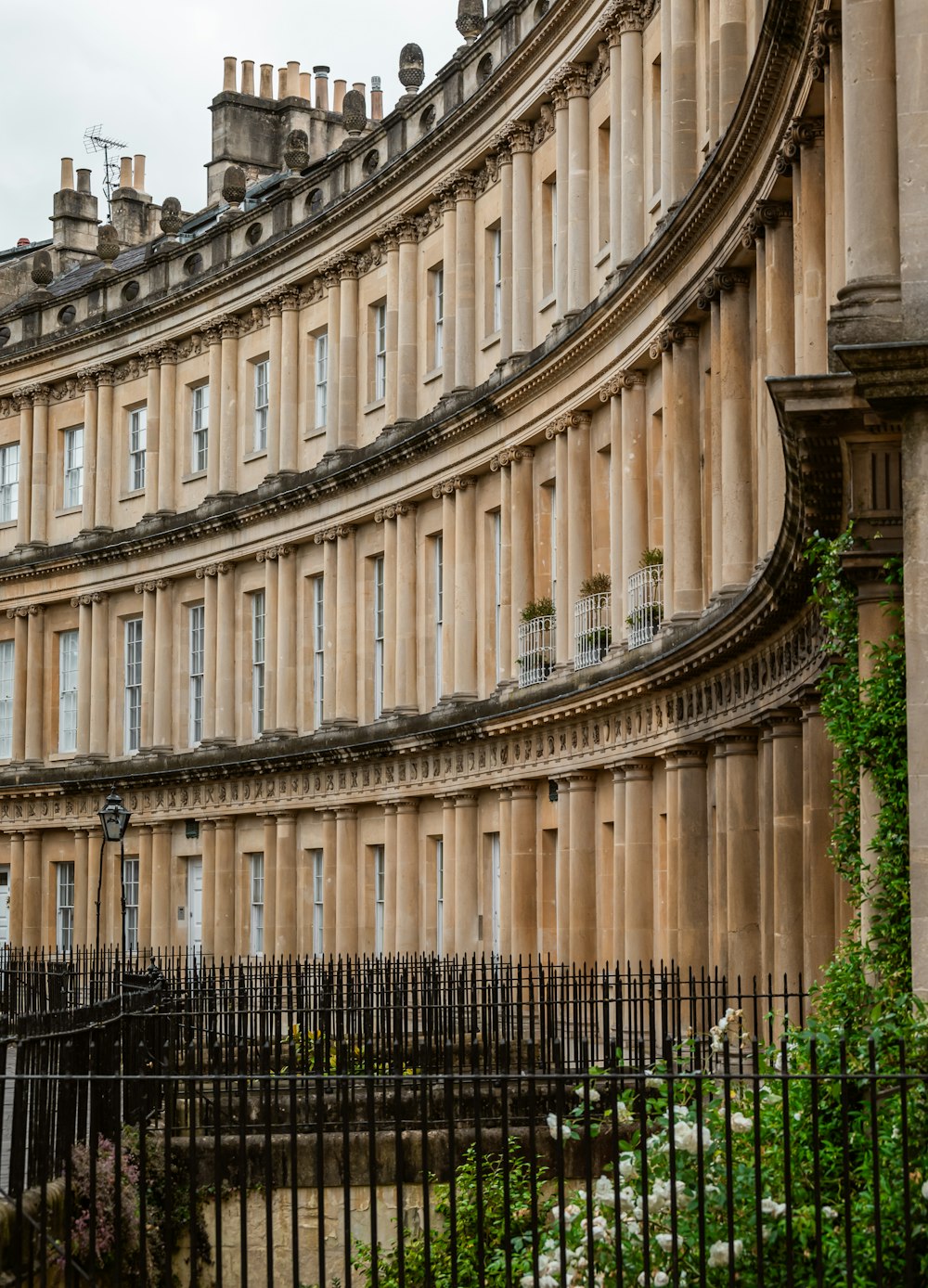 a large building with many windows next to a fence