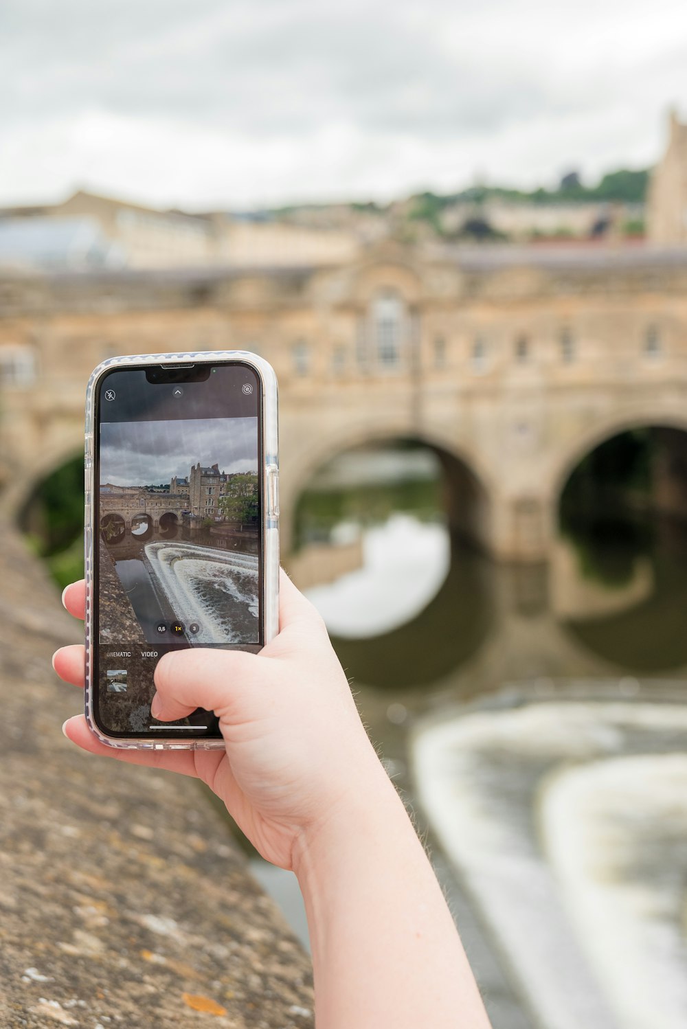 una persona tomando una foto de un puente con un teléfono celular