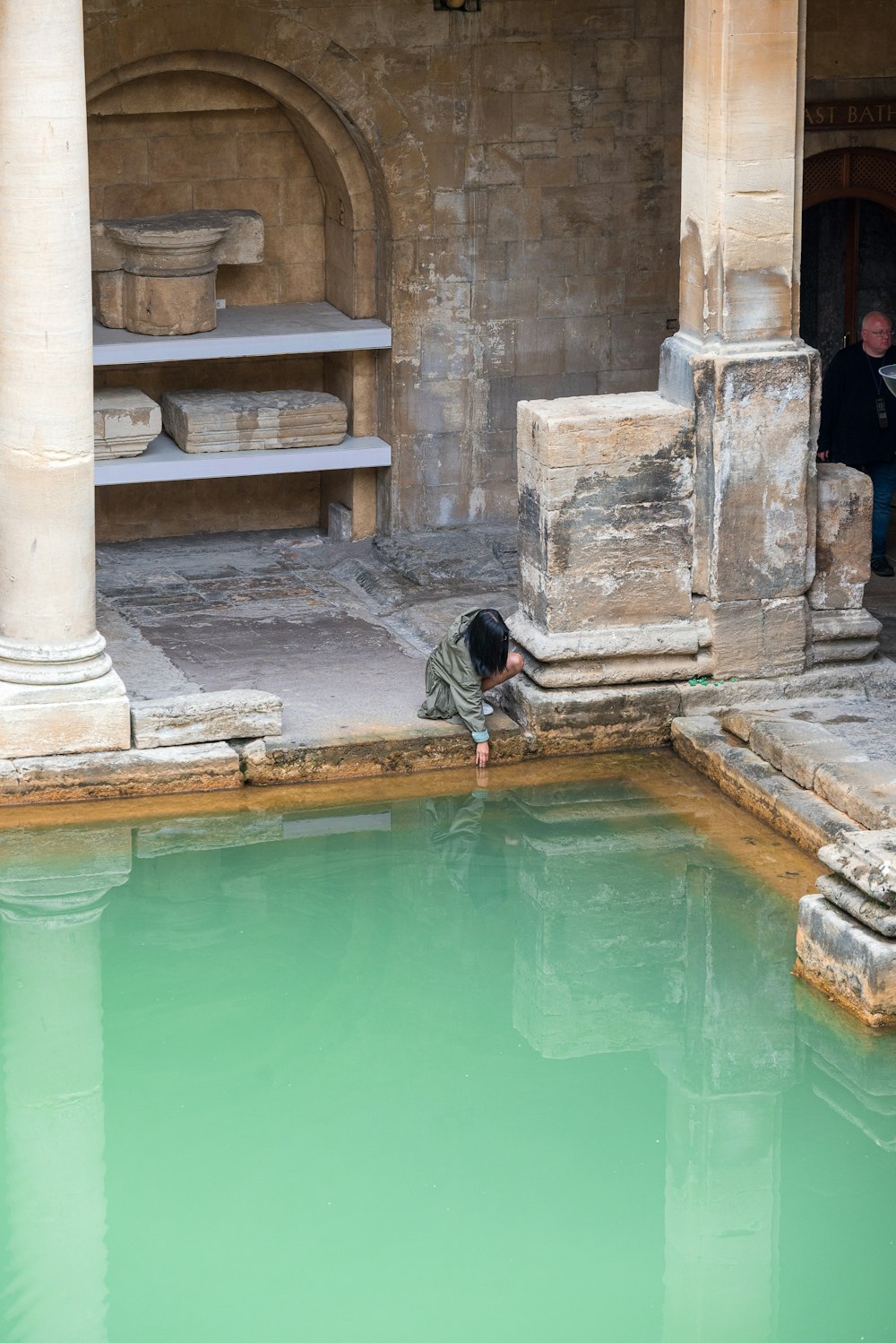 a man standing next to a pool of water