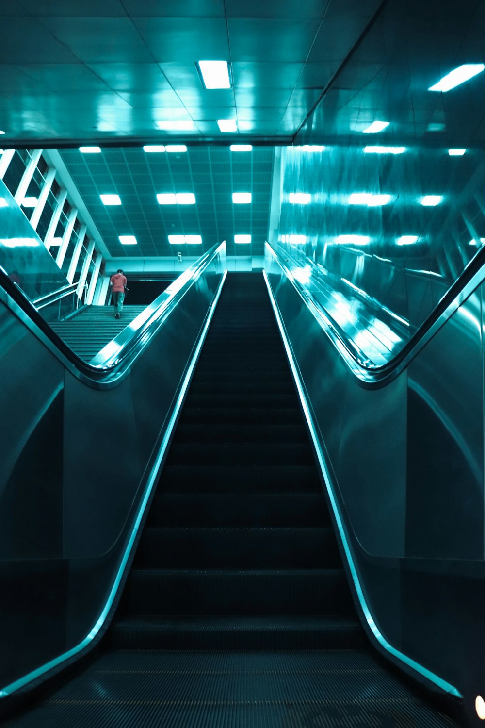 an escalator in a subway station with blue lights