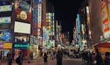 A bustling street in Tokyo filled with neon lights.