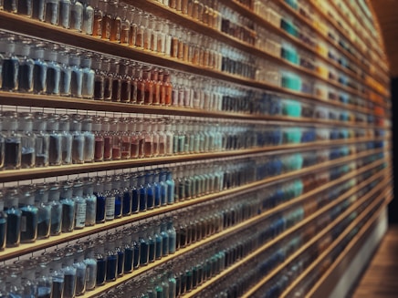 Brightly lit glass jars filled with colorful natural powders on a wooden table