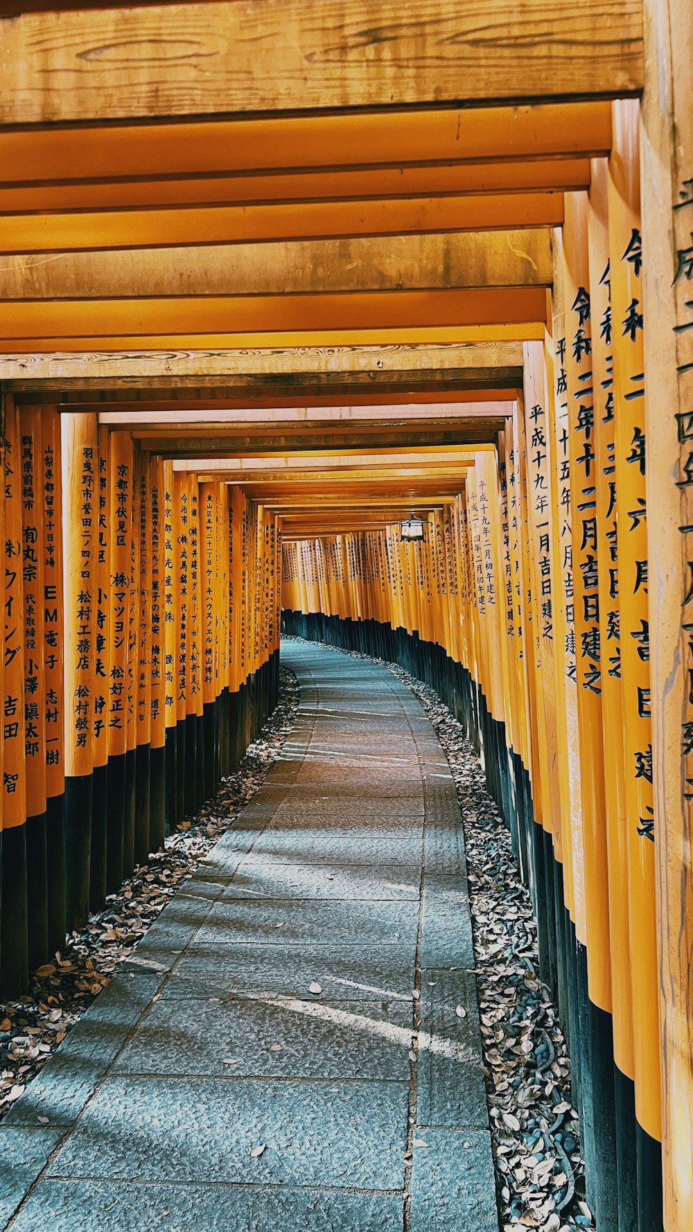 a row of yellow wooden pillars with writing on them