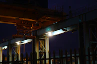 Night view of a steel workshop illuminated, highlighting structural details and safety measures.