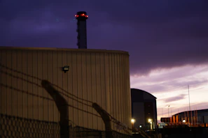 Evening image of a well-lit, secure industrial facility with deep navy and charcoal tones.
