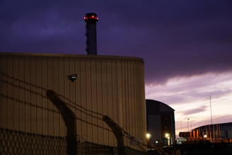 A large industrial generator powered on, set against a dark evening sky