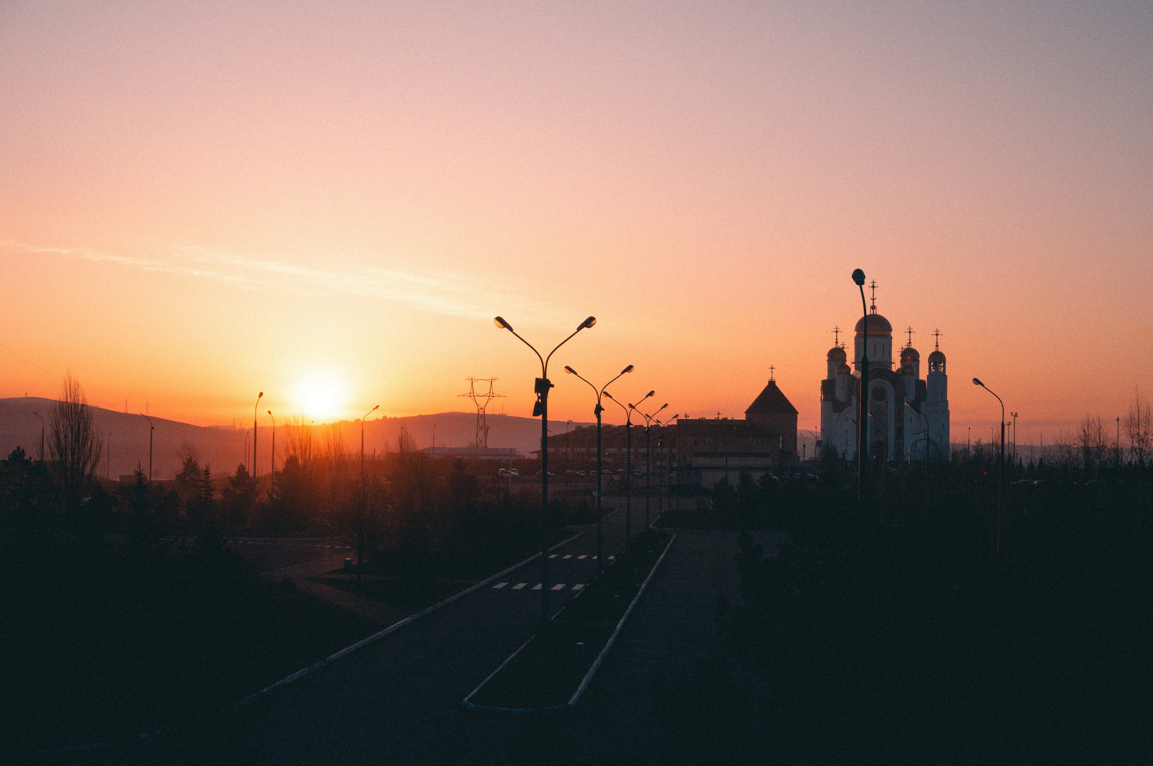 the sun is setting over a city with tall buildings