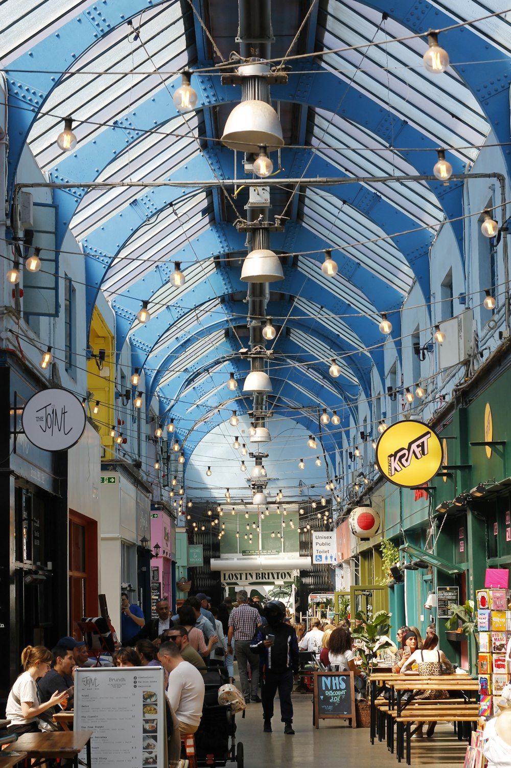 a group of people walking through a shopping mall