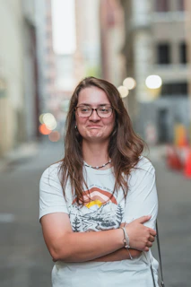 Model wearing a bold graphic t-shirt in an urban alleyway with purple neon lights