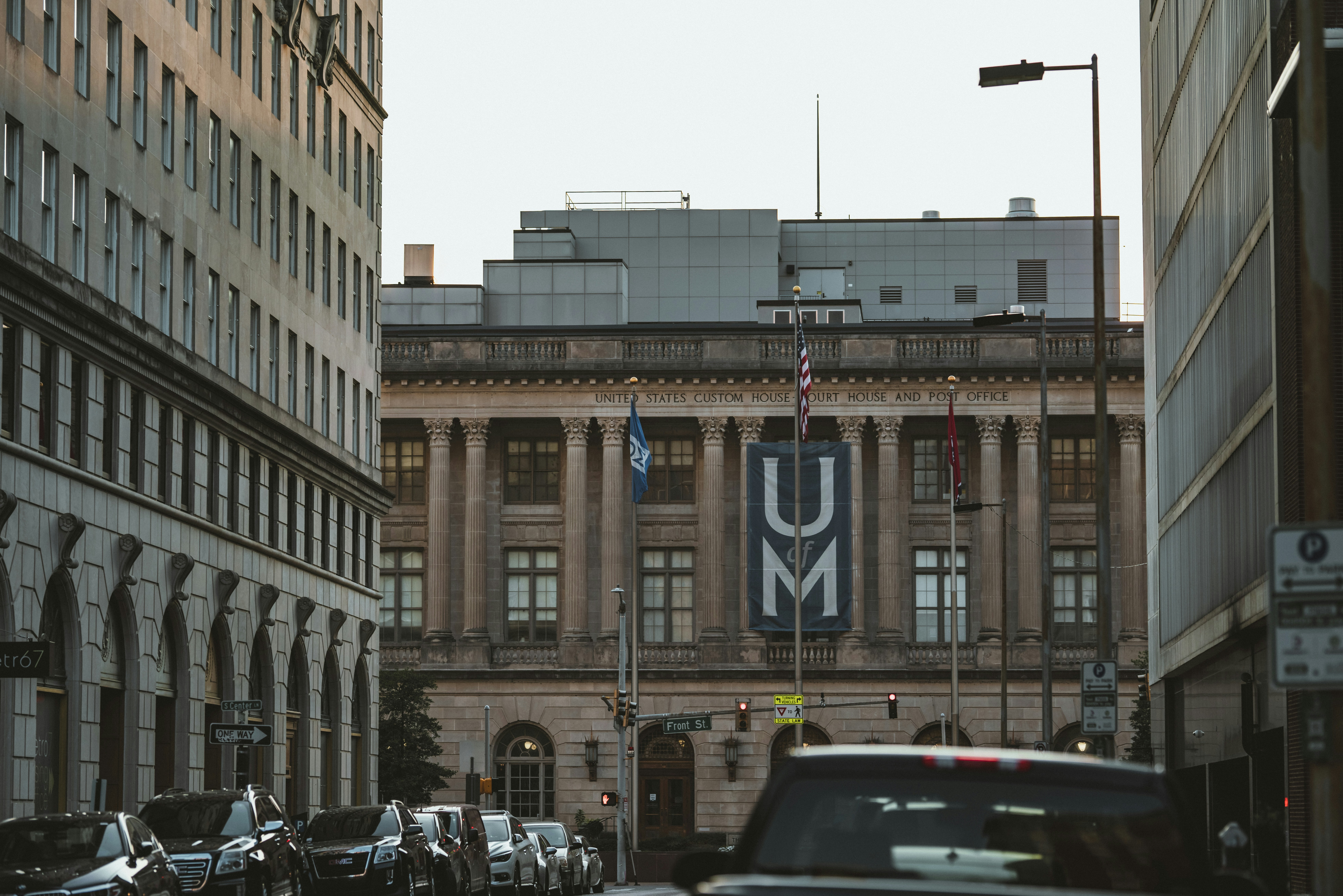a car driving down a street next to tall buildings