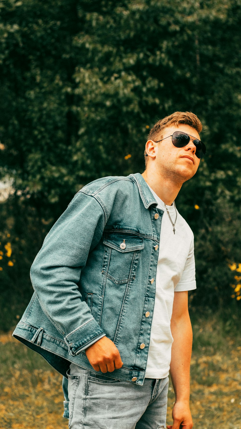 a man wearing sunglasses and a denim jacket