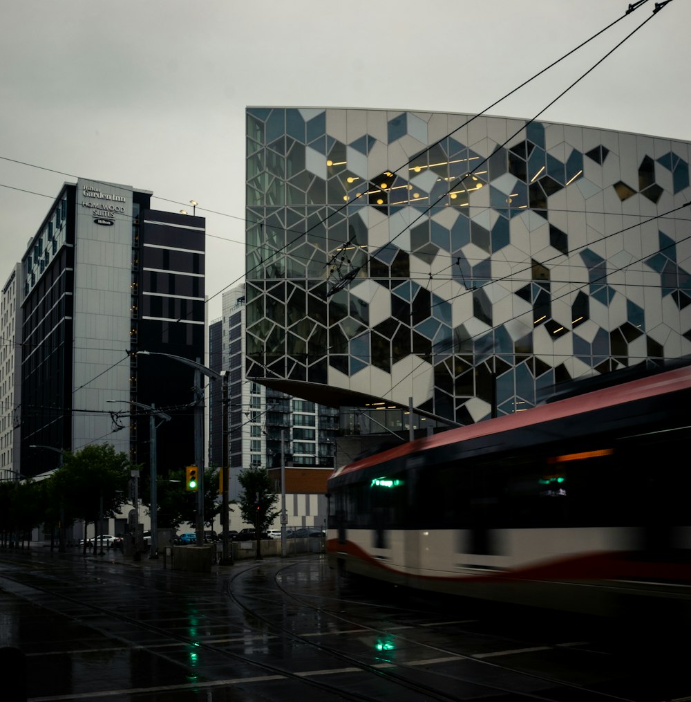 a bus driving down a street next to tall buildings