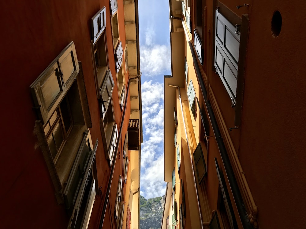 looking up at a narrow alleyway with windows and balconies