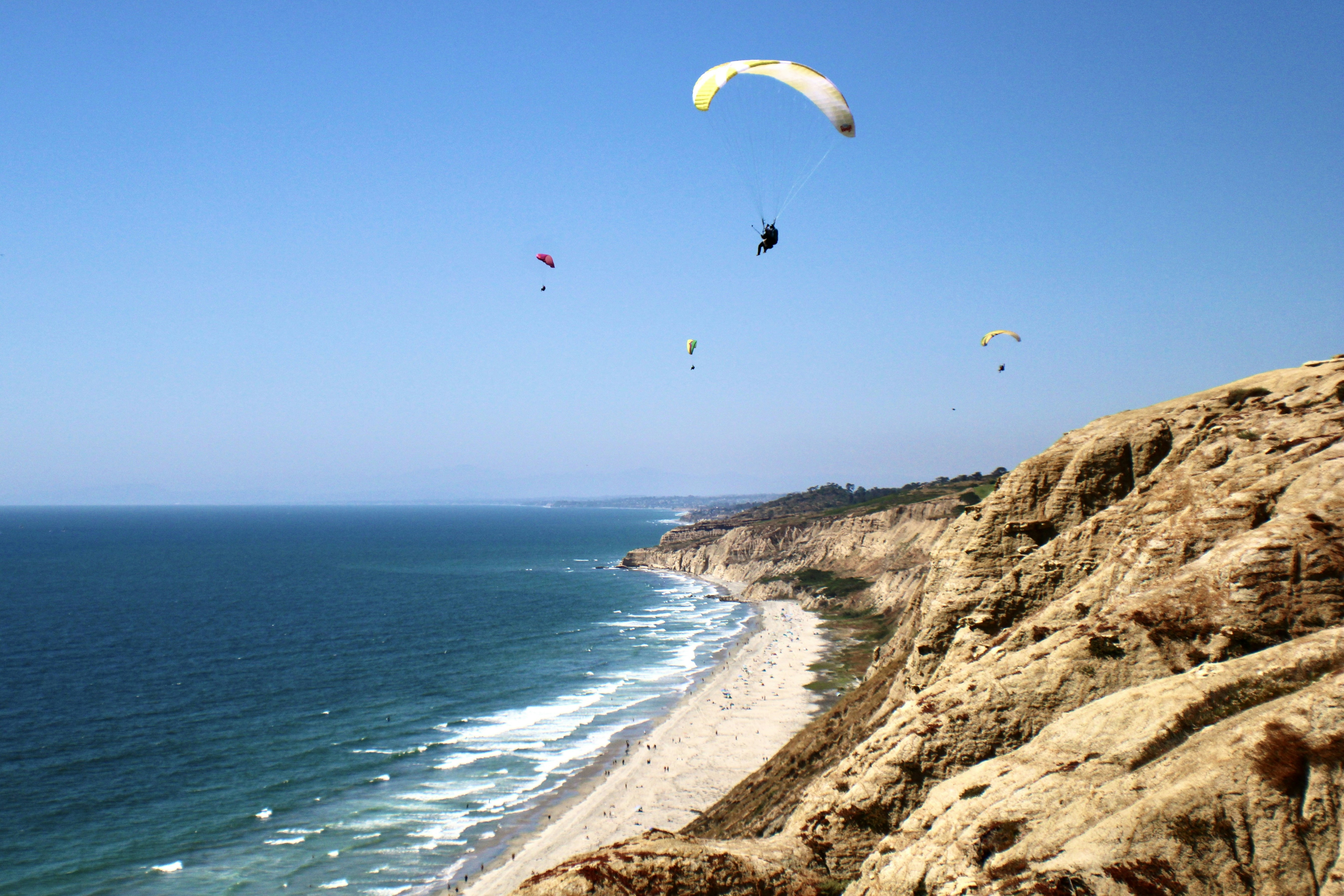 a group of people flying kites over the ocean