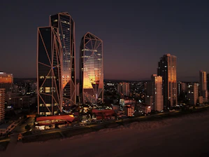 A sleek Manila skyline at dusk blending into a serene luxury beach villa, symbolizing the balance of business and leisure.