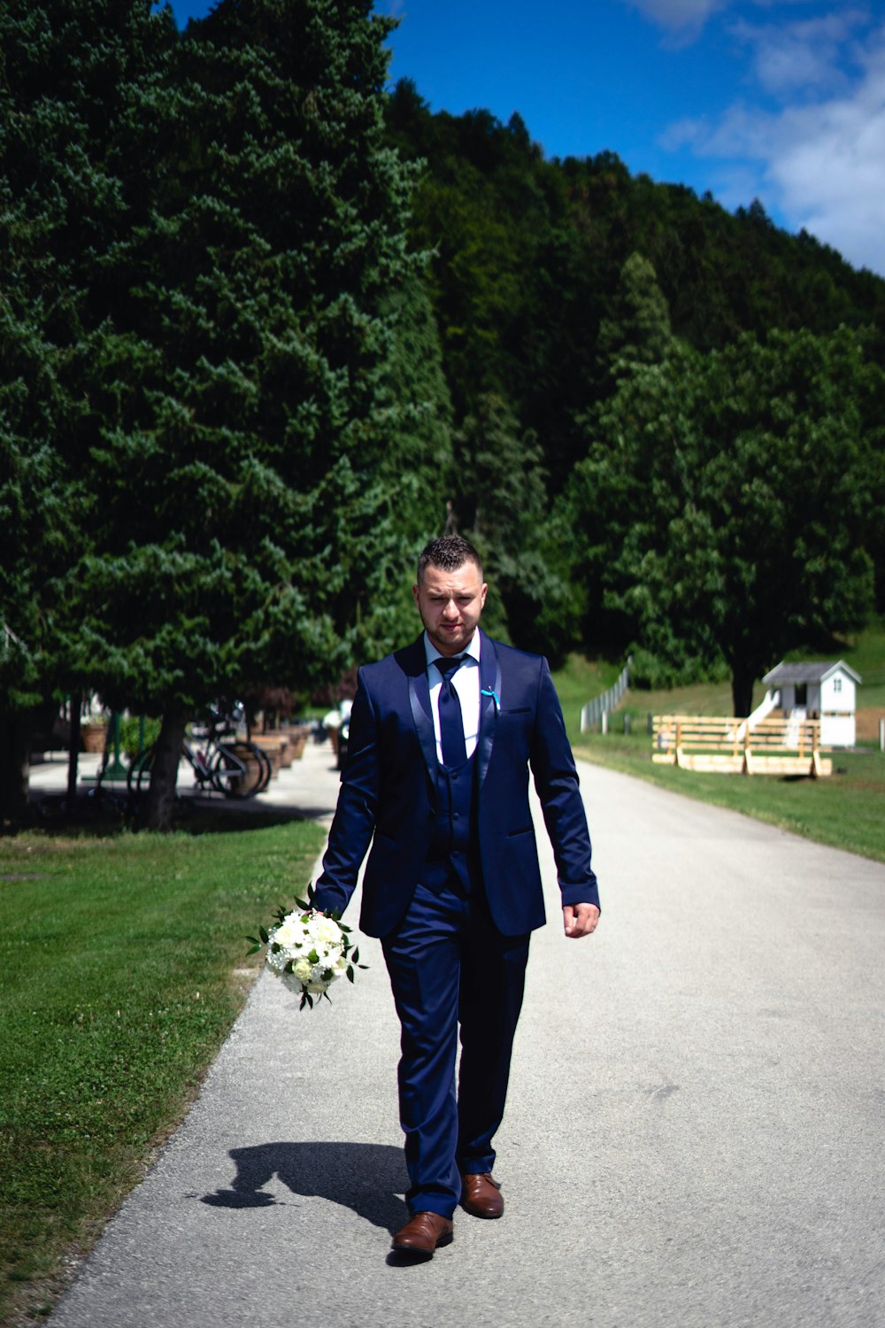 a man in a suit walking down a path