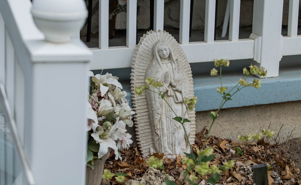 a statue of the virgin mary in front of a porch