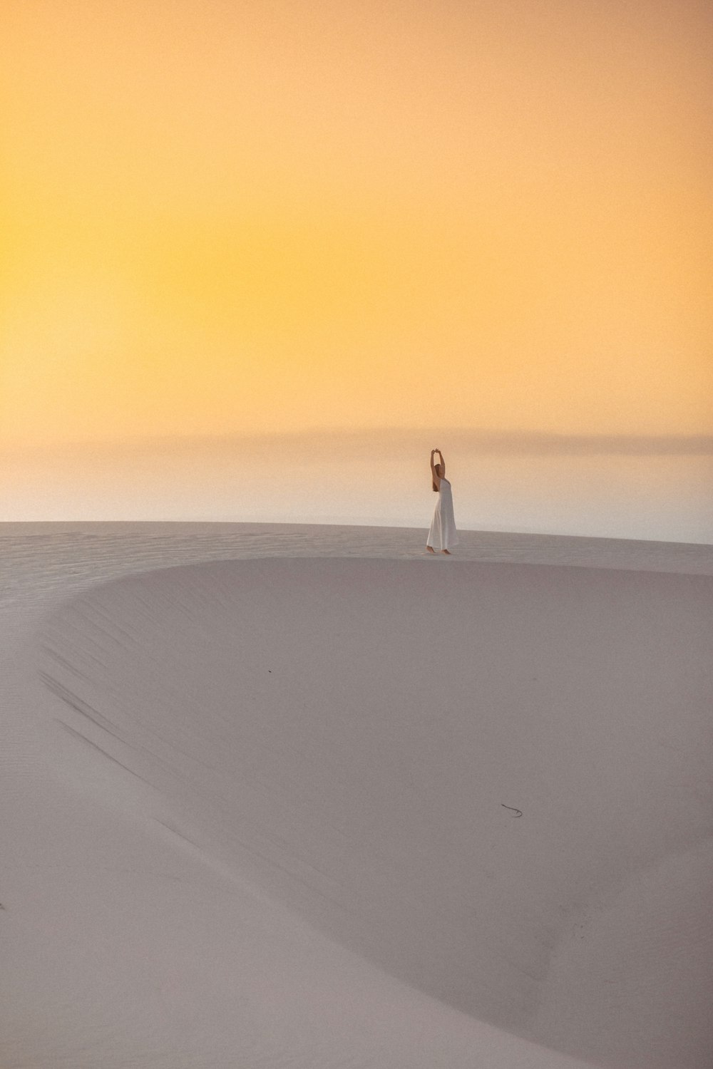 a woman standing on top of a sandy beach