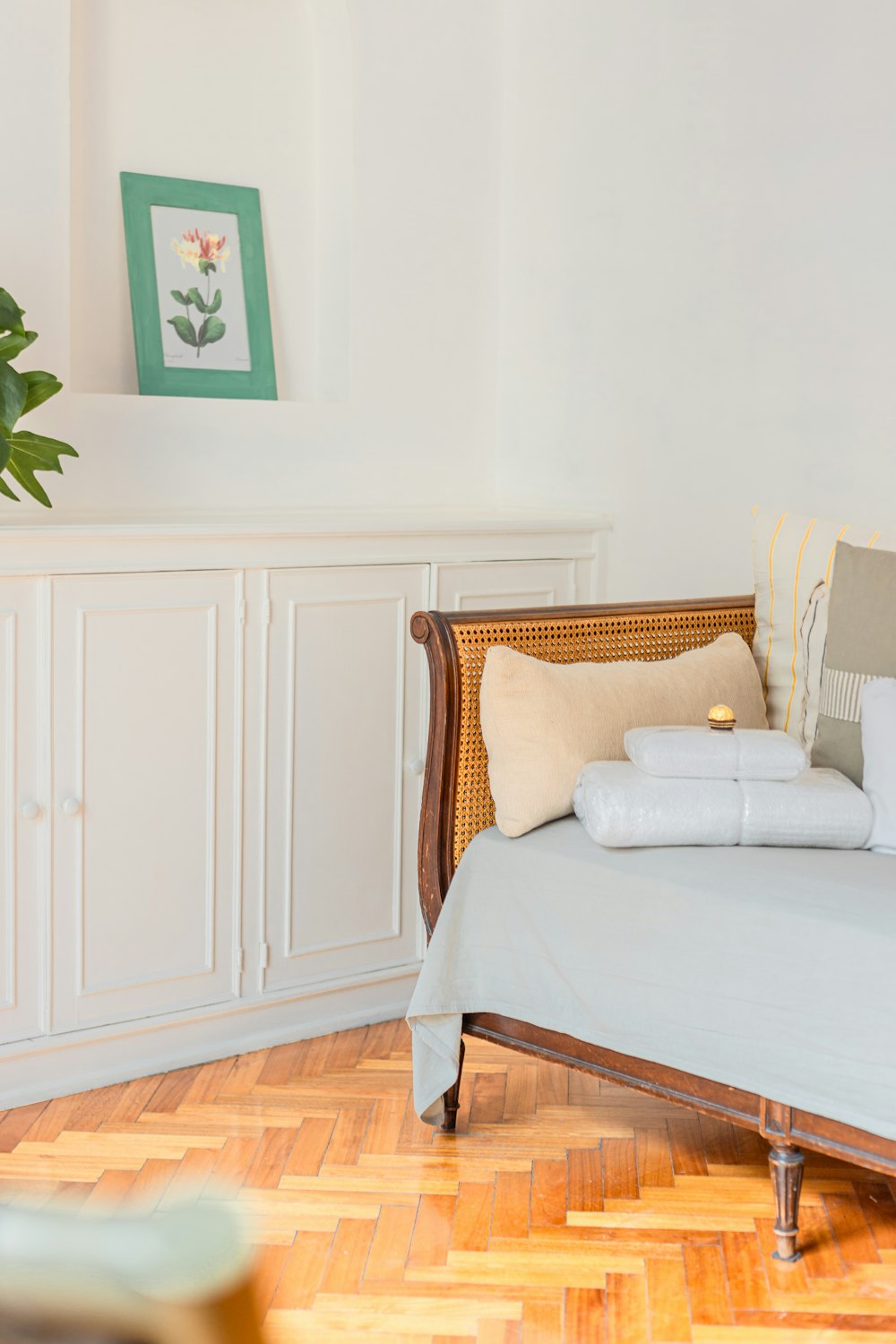 a bed with white sheets and pillows in a room