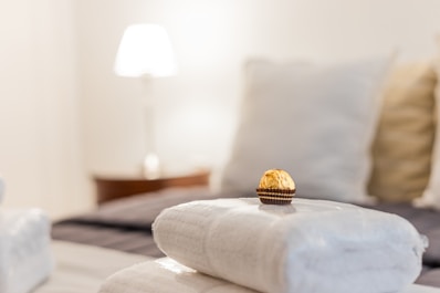 a stack of folded towels sitting on top of a bed