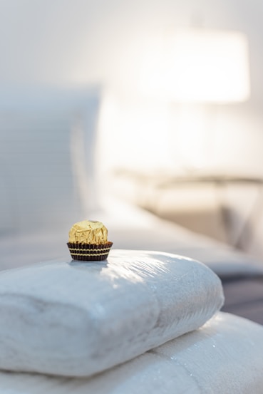 a cupcake sitting on top of a pile of pillows