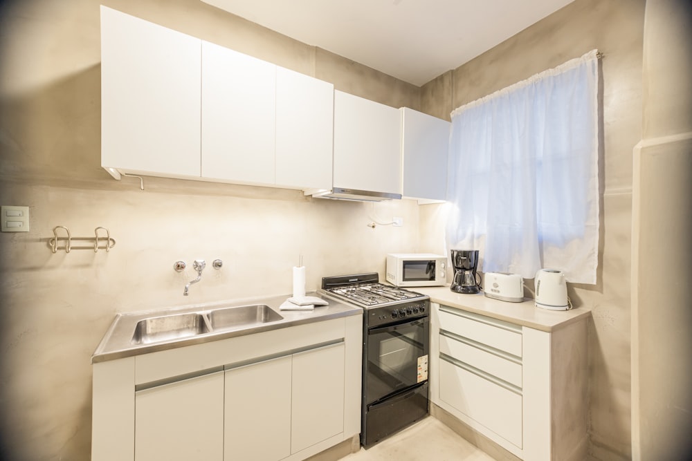 a kitchen with a sink, stove and microwave