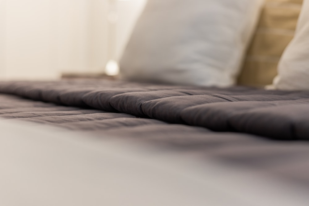 a close up of a bed with white pillows