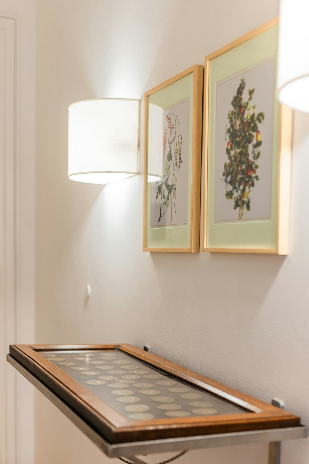 a table with a lamp and pictures on the wall
