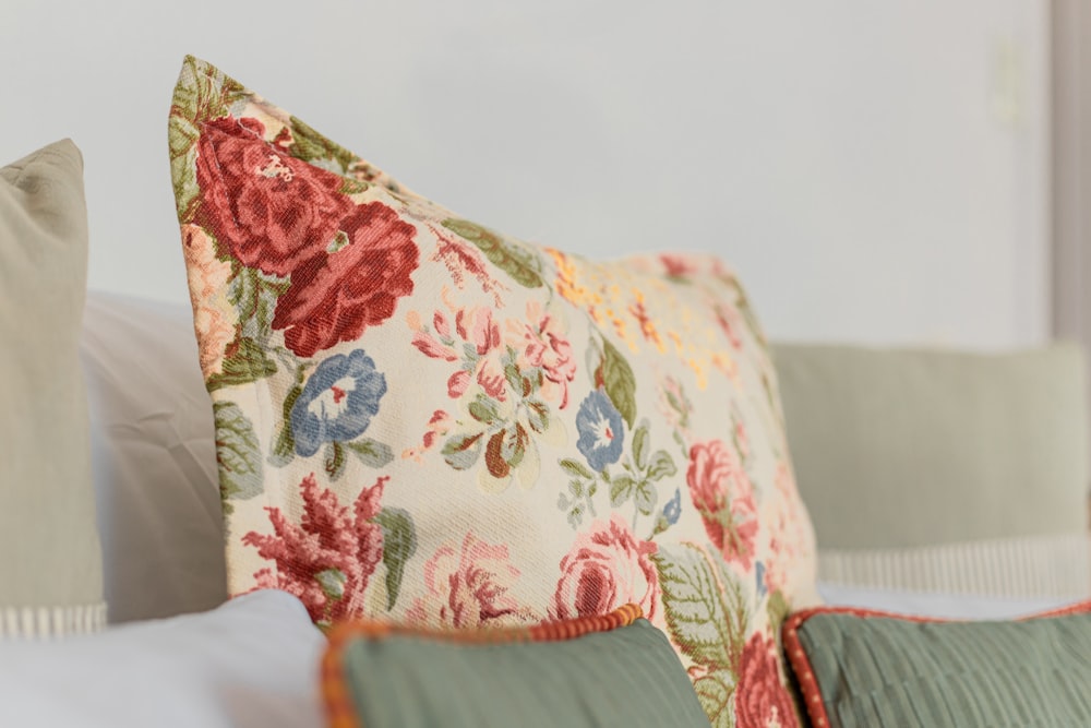 a close up of a flowered pillow on a bed