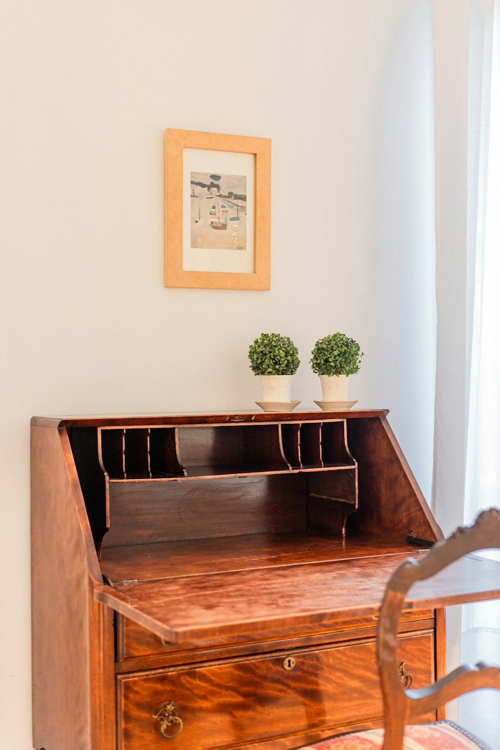 a wooden desk with two potted plants on top of it
