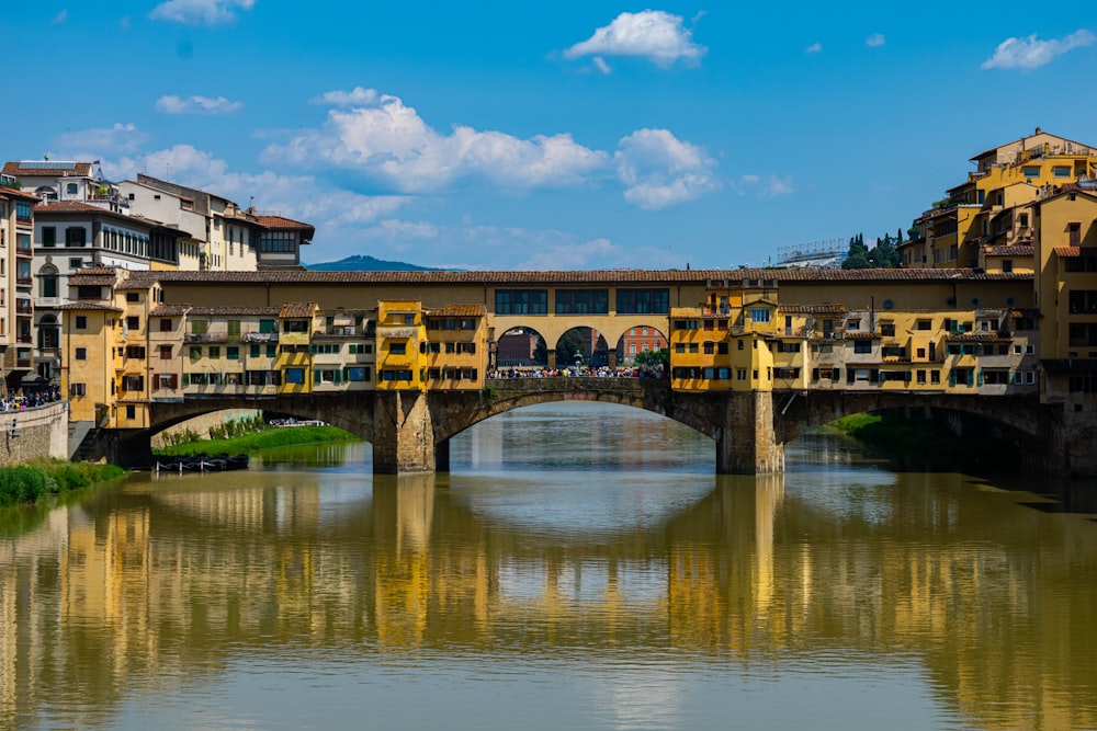 a bridge over a body of water with buildings in the background