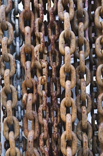 a bunch of rusted metal chains hanging from a ceiling
